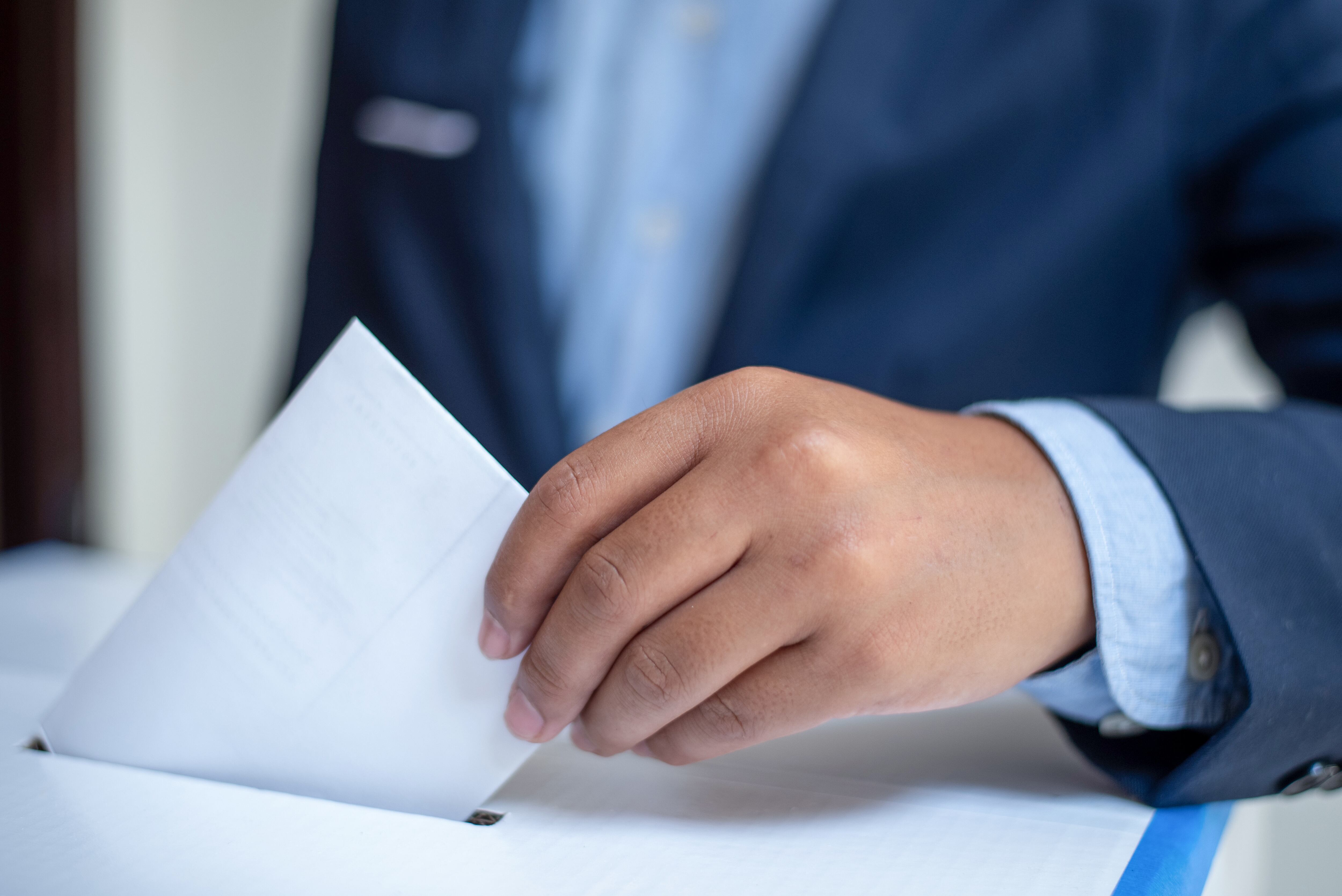 Ballot box with person casting vote.