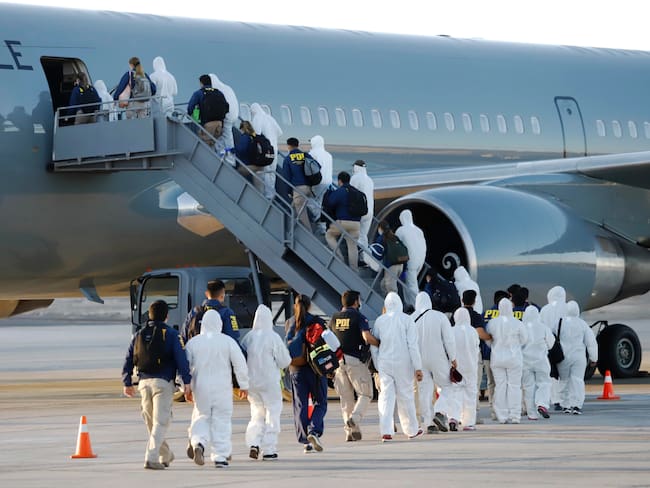 Migrantes venezolanos abordando avión para ser deportados a Chile | Crédito: AFP