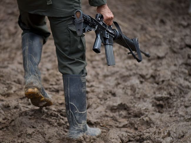 TOPSHOT - A member of the Revolutionary Armed Forces of Colombia (FARC) guerrilla carries his rifle at the &quot;Alfonso Artiaga&quot; Front 29 FARC encampment in a rural area of Policarpa, department of Narino  in southwestern Colombia, on January 16, 2017.The UN is overseeing the FARC&#039;s disarmament as part of a peace deal the leftist guerrillas signed with the government to end a more than five-decade conflict. The FARC&#039;s 5,700 fighters are now in camps waiting to be transferred to UN-monitored ZVTN transitional zones where they will demobilize and begin their path to civilian life and legality over a period of six months. But the delay in setting up the camps has hindered their transfer to these areas. / AFP / LUIS ROBAYO        (Photo credit should read LUIS ROBAYO/AFP via Getty Images)