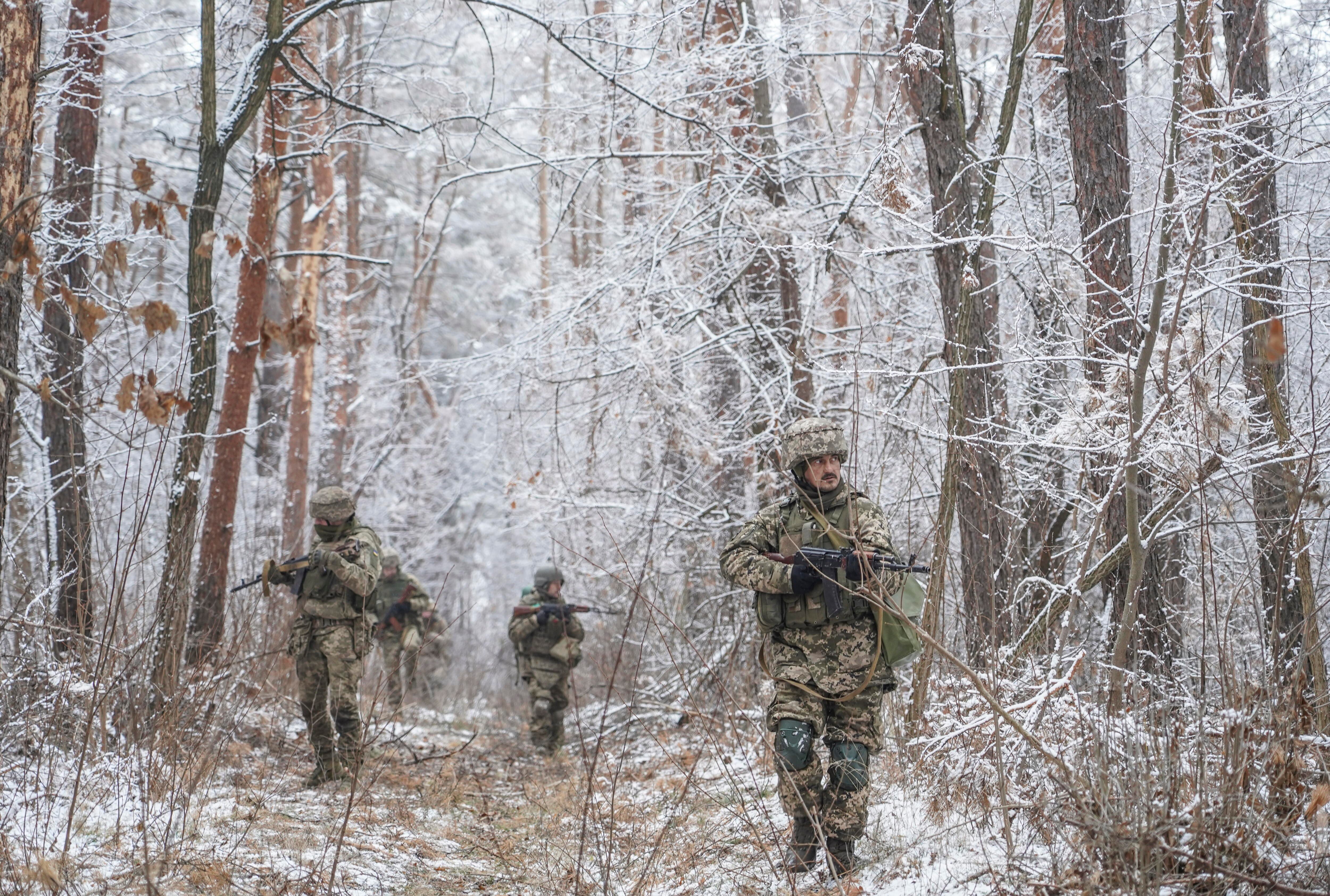 Dnipro (Ucrania), 13/01/2025.- Militares de la 33ª Brigada Mecanizada Separada aprendiendo a patrullar y a camuflarse en el bosque como parte de su entrenamiento.