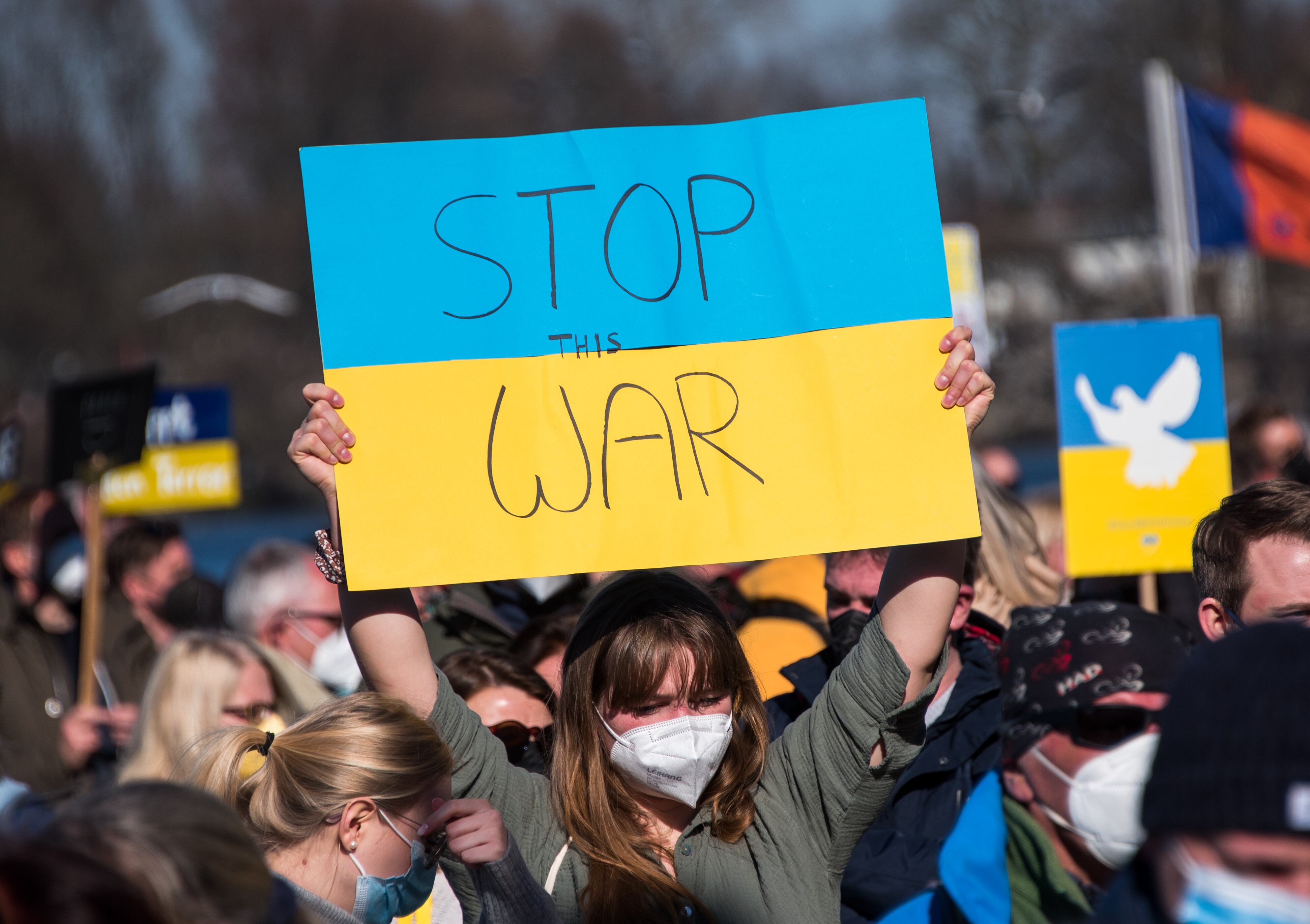 13 March 2022, Hamburg: A participant in a demonstration against the Ukraine conflict stands on the Jungfernstieg and holds up a placard reading "Stop the war". Photo: Daniel Bockwoldt/dpa (Photo by Daniel Bockwoldt/picture alliance via Getty Images)