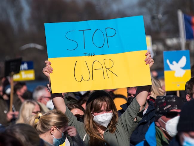 13 March 2022, Hamburg: A participant in a demonstration against the Ukraine conflict stands on the Jungfernstieg and holds up a placard reading &quot;Stop the war&quot;. Photo: Daniel Bockwoldt/dpa (Photo by Daniel Bockwoldt/picture alliance via Getty Images)