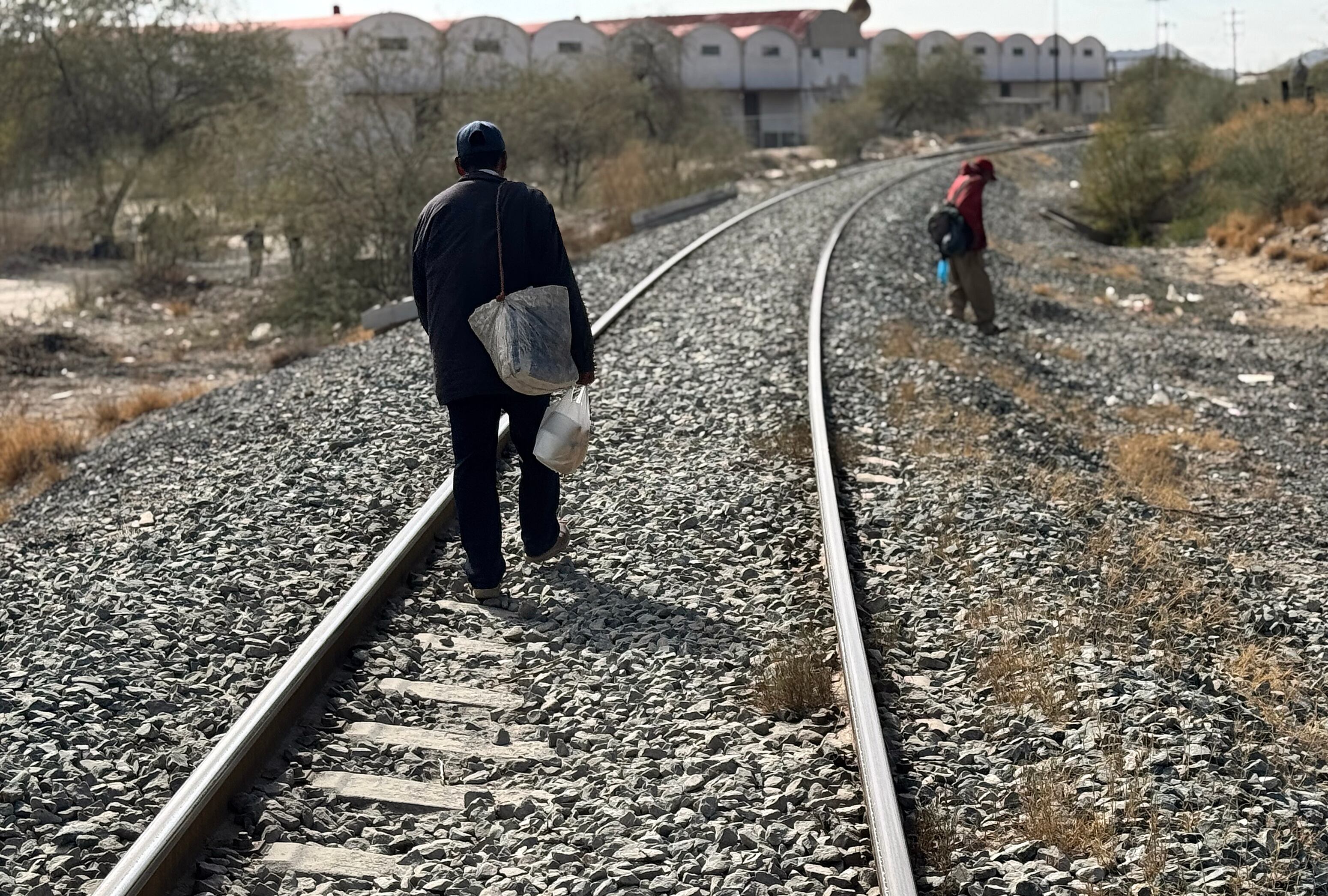 Dos migrantes caminan por unas vías de tren, a pesar del reforzamiento de la vigilancia fronteriza. FOTO: EFE/ Daniel Sánchez