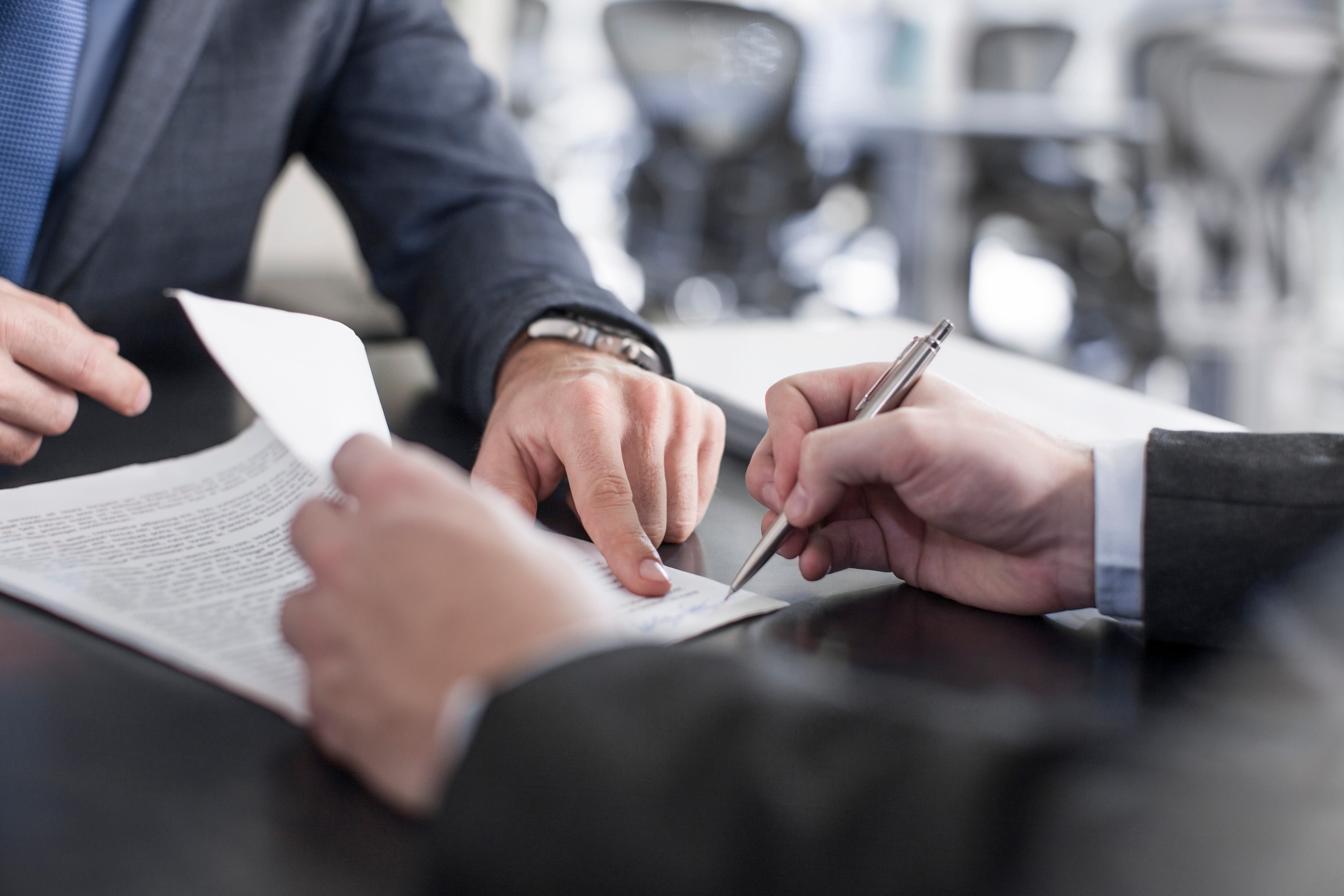 Cape Town, South Africa, Businessman sitting with client signing notes at desk,New York