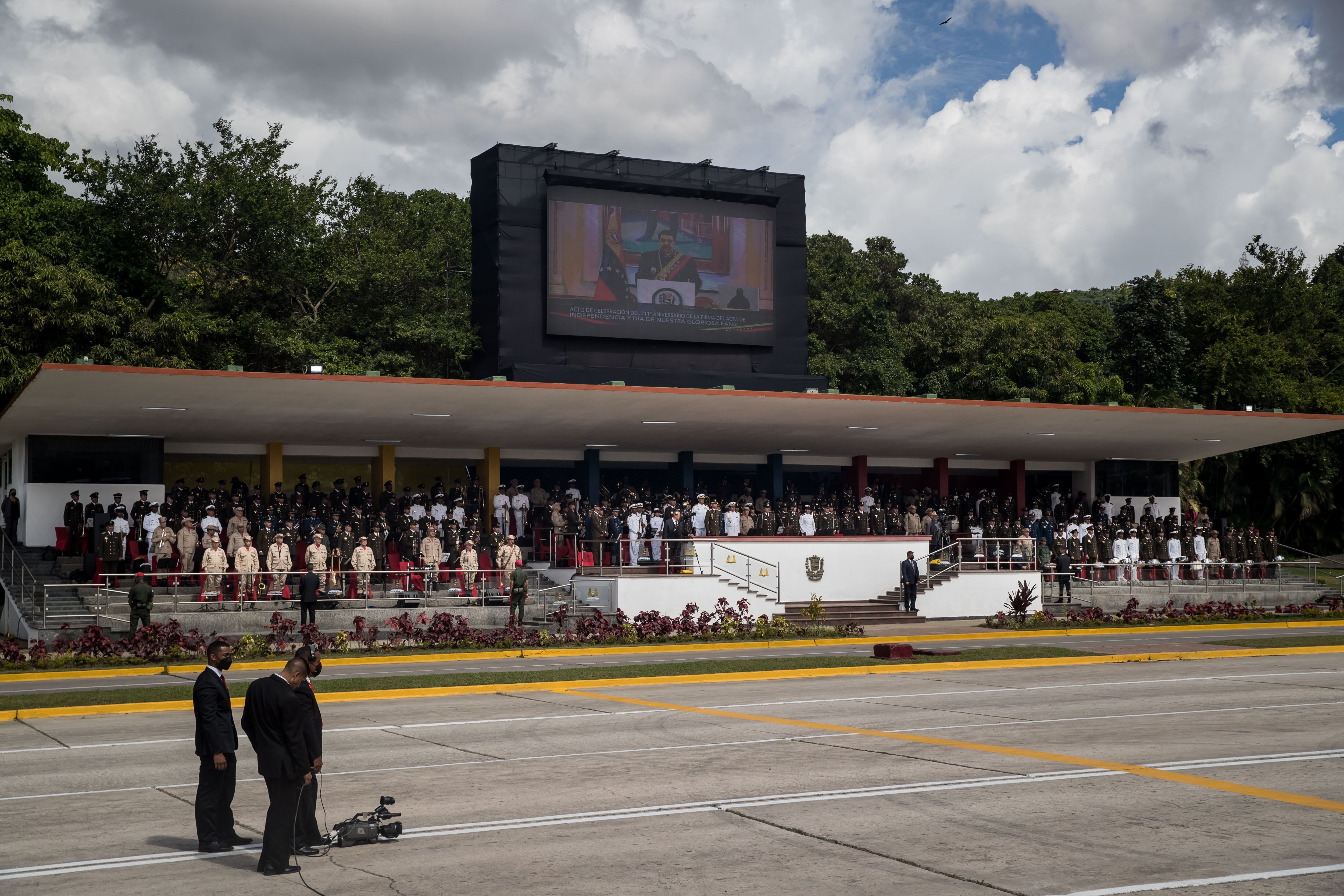 El presidente de Venezuela, Nicolás Maduro (en la pantalla), brinda un mensaje ante los miembros de las Fuerzas Armadas y civiles que participan en el desfile cívico-militar para conmemorar los 211 años de la Firma del Acta de la Independencia de Venezuela. EFE/ Miguel Gutiérrez