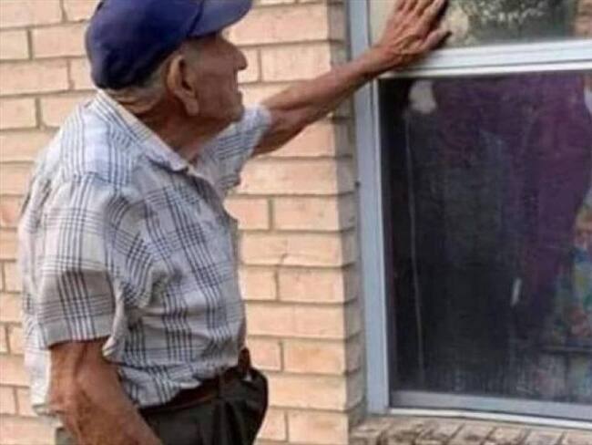 Anciano ha visitado todos los días a su esposa por una ventana durante la cuarentena. Foto: Cortesía