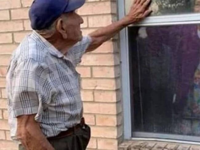 Anciano ha visitado todos los días a su esposa por una ventana durante la cuarentena. Foto: Cortesía