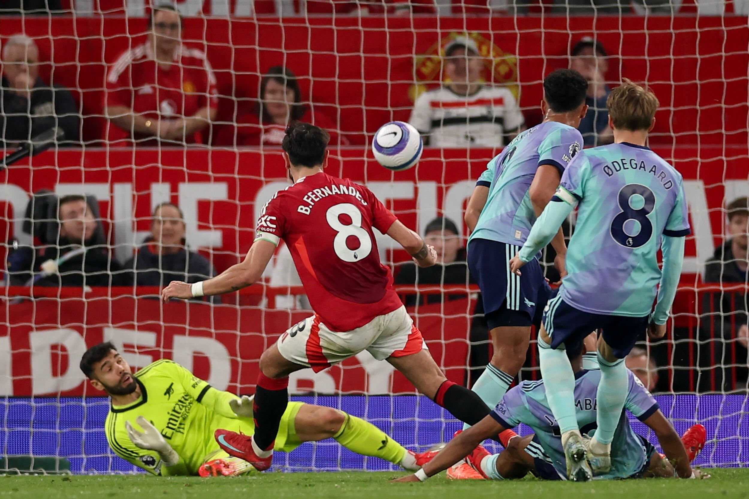 MANCHESTER (United Kingdom), 09/03/2025.- Bruno Fernandes (C) of Manchester United in action against goalkepeer David Raya (L) of Arsenal during the English Premier League match between Manchester United and Arsenal FC, in Manchester, Britain, 09 March 2025. (Reino Unido) EFE/EPA/ADAM VAUGHAN EDITORIAL USE ONLY. No use with unauthorized audio, video, data, fixture lists, club/league logos, 'live' services or NFTs. Online in-match use limited to 120 images, no video emulation. No use in betting, games or single club/league/player publications.