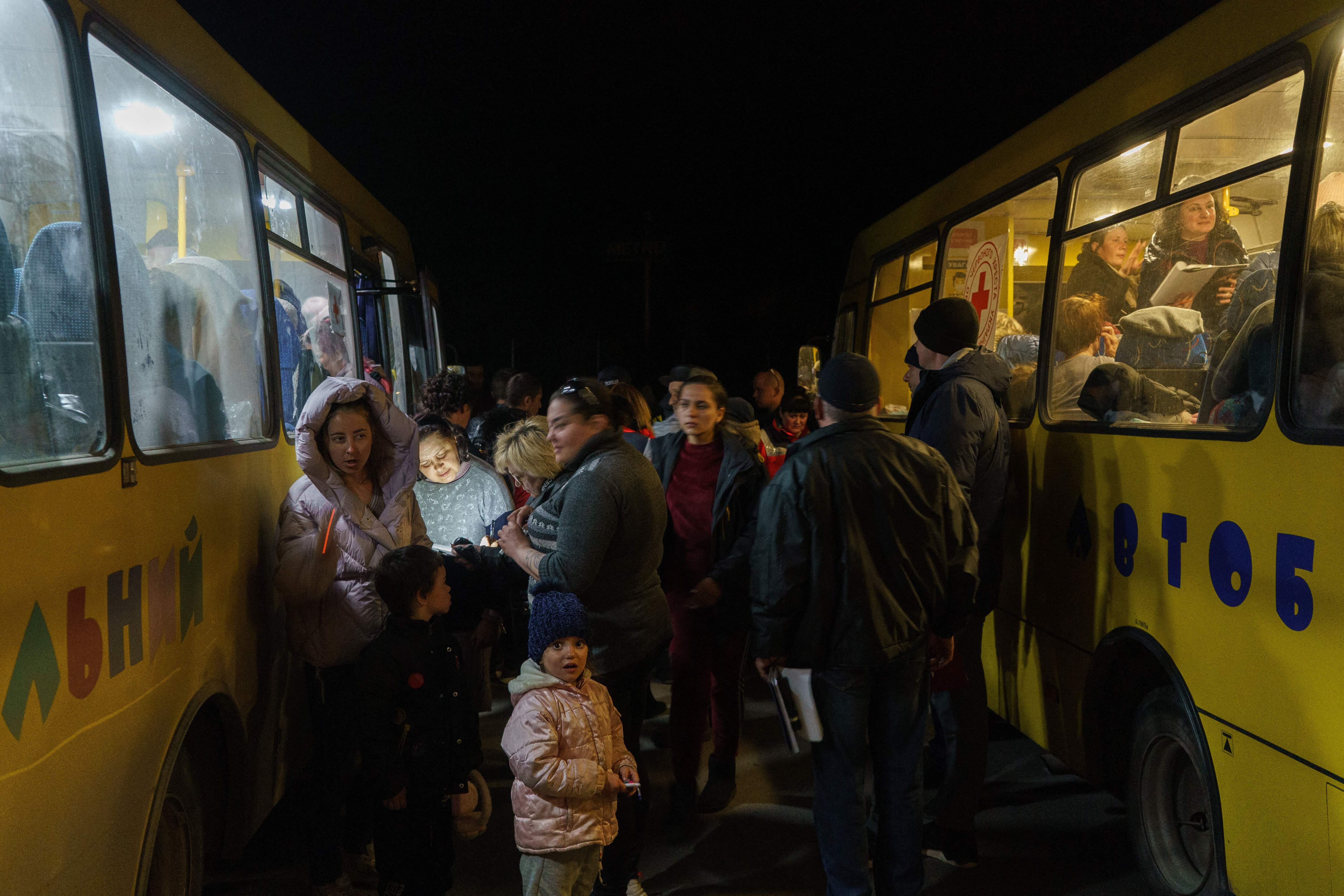 Women and children disembark as a convoy of 30 buses carrying evacuees from Mariupol and Melitopol arrive at the registration center in Zaporizhzhia, on April 1, 2022. - Late on April 1, people who managed to flee Mariupol to Russian-occupied Berdiansk were from there carried on dozens of buses to Zaporizhzhia, some 200 kilometers (120 miles) to the northwest, according to an AFP reporter on the scene. (Photo by emre caylak / AFP) (Photo by EMRE CAYLAK/AFP via Getty Images)