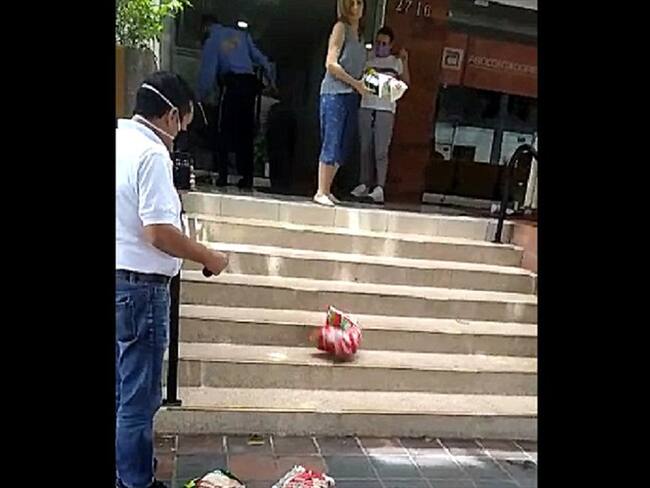 Botan alimentos en plena vía pública. . Foto:tomada del video.