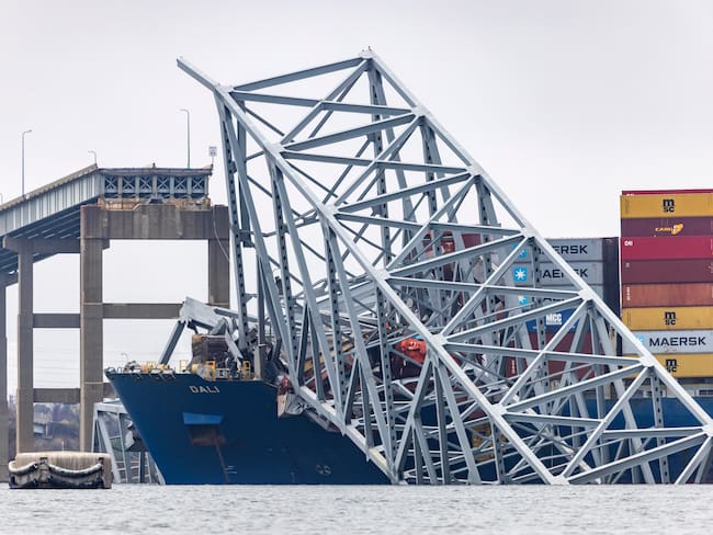 Baltimore (United States), 27/03/2024.- Wreckage from the Francis Scott Key Bridge remains on top of the 984-foot cargo ship Dali after the vessel lost power and collided with the 51-year-old bridge in Baltimore, Maryland, USA, 27 March 2024. The Francis Scott Key Bridge collapsed due to a ship strike on 26 March 2024. Two people were rescued, while at least six others, all members of a construction crew working on the bridge at the time of the incident according to authorities, were still missing. Divers are working to recover the bodies of the six missing construction workers, who are now presumed dead, the US Coast Guard said. EFE/EPA/JIM LO SCALZO