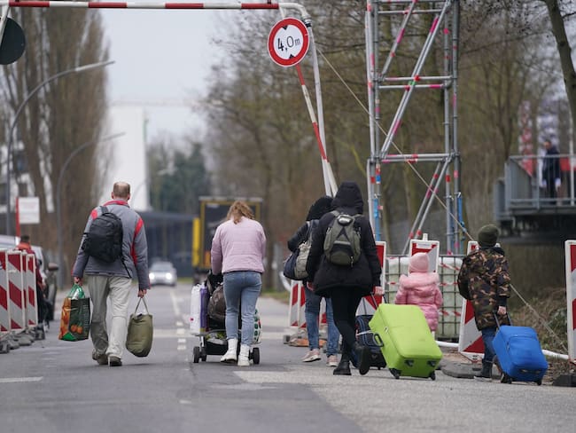 14 March 2022, Hamburg: Ukrainian refugees leave the refugee shelter in the former Fegro wholesale market in the Harburg district with their luggage. Photo: Marcus Brandt/dpa (Photo by Marcus Brandt/picture alliance via Getty Images)
