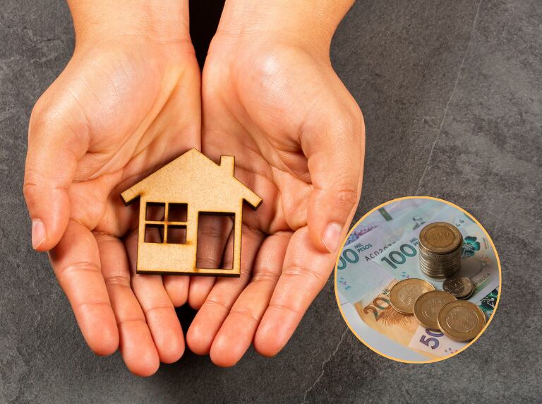 Persona con una casa de madera en sus manos / Dinero colombiano (Getty Images)