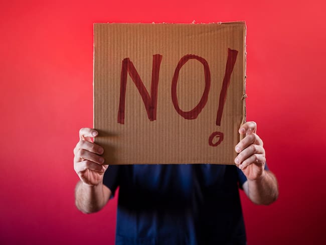 Doctor holding a cardboard sign that says NO!.