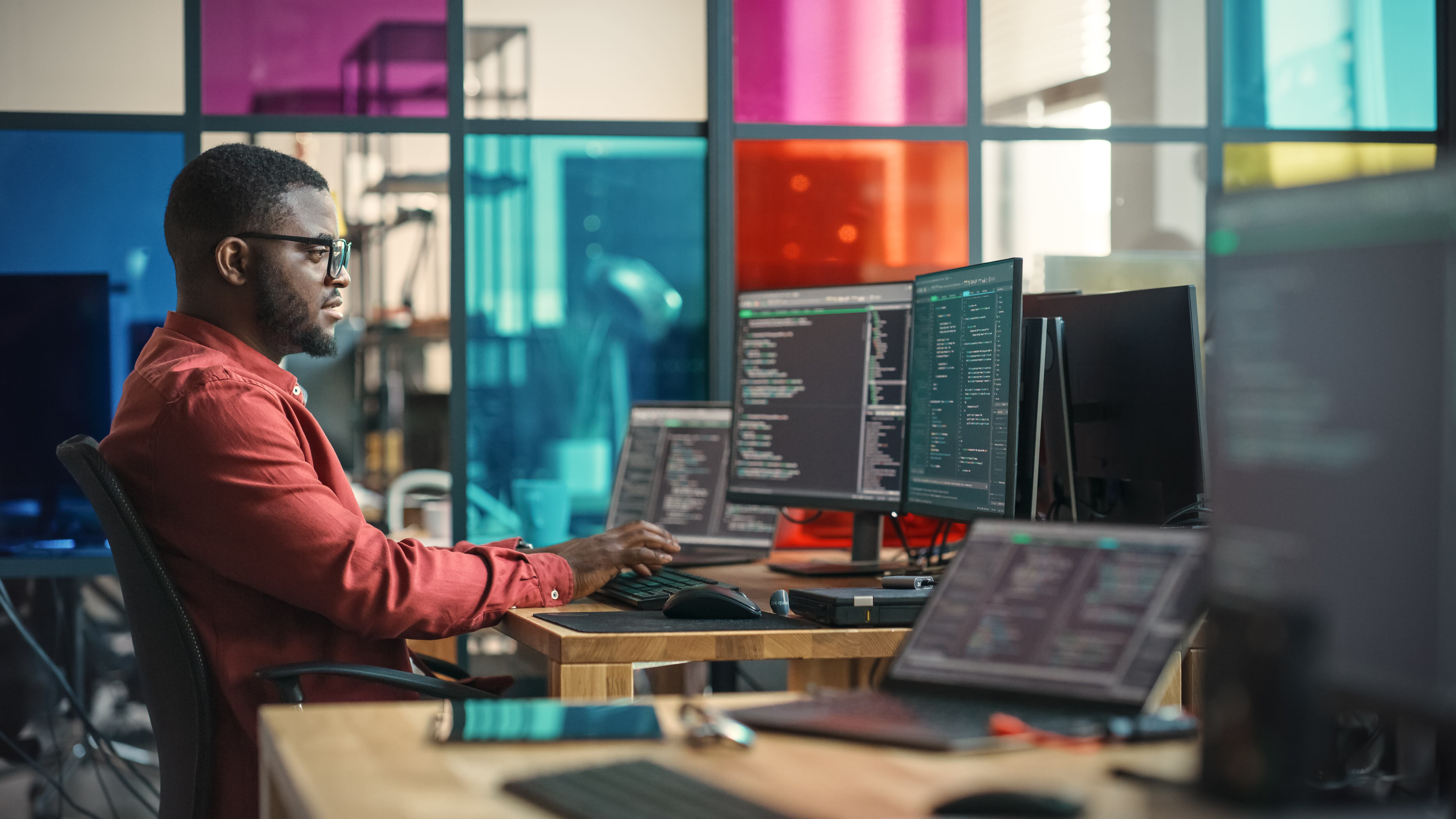 Hombre escribiendo líneas de código en un computador de escritorio (Foto vía GettyImages)