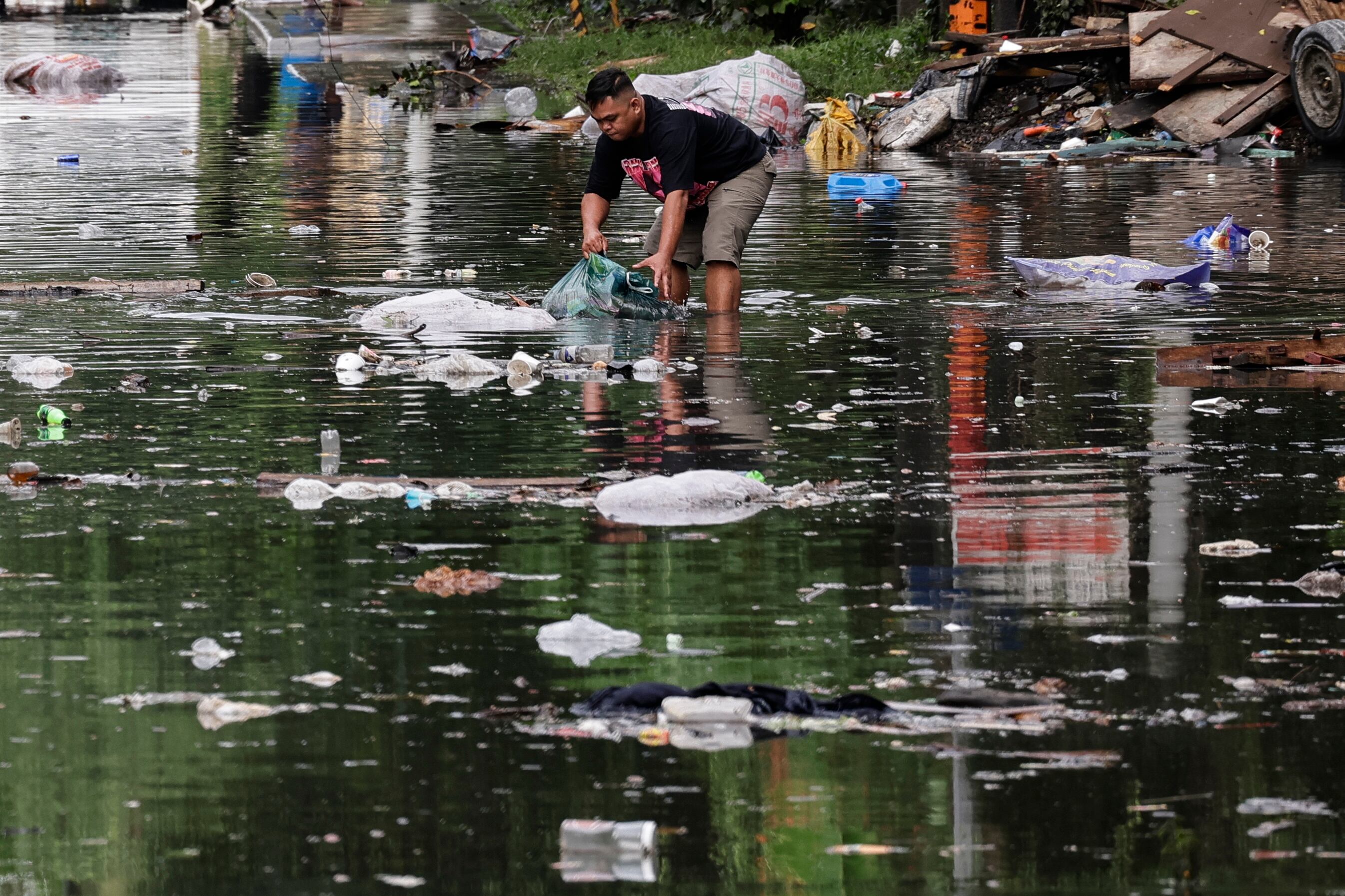 QUEZON CITY (Philippines), 07/07/2025.- A resident collects trash floating in subsiding floodwater following early morning heavy rains in Quezon City, Metro Manila, Philippines, 07 July 2025. A southwest monsoon continues to affect northern regions of the Philippines as Typhoon Danas moves from Philippine territory over to parts of Taiwan, according to the Philippines' weather bureau. (Inundaciones, Filipinas) EFE/EPA/ROLEX DELA PENA