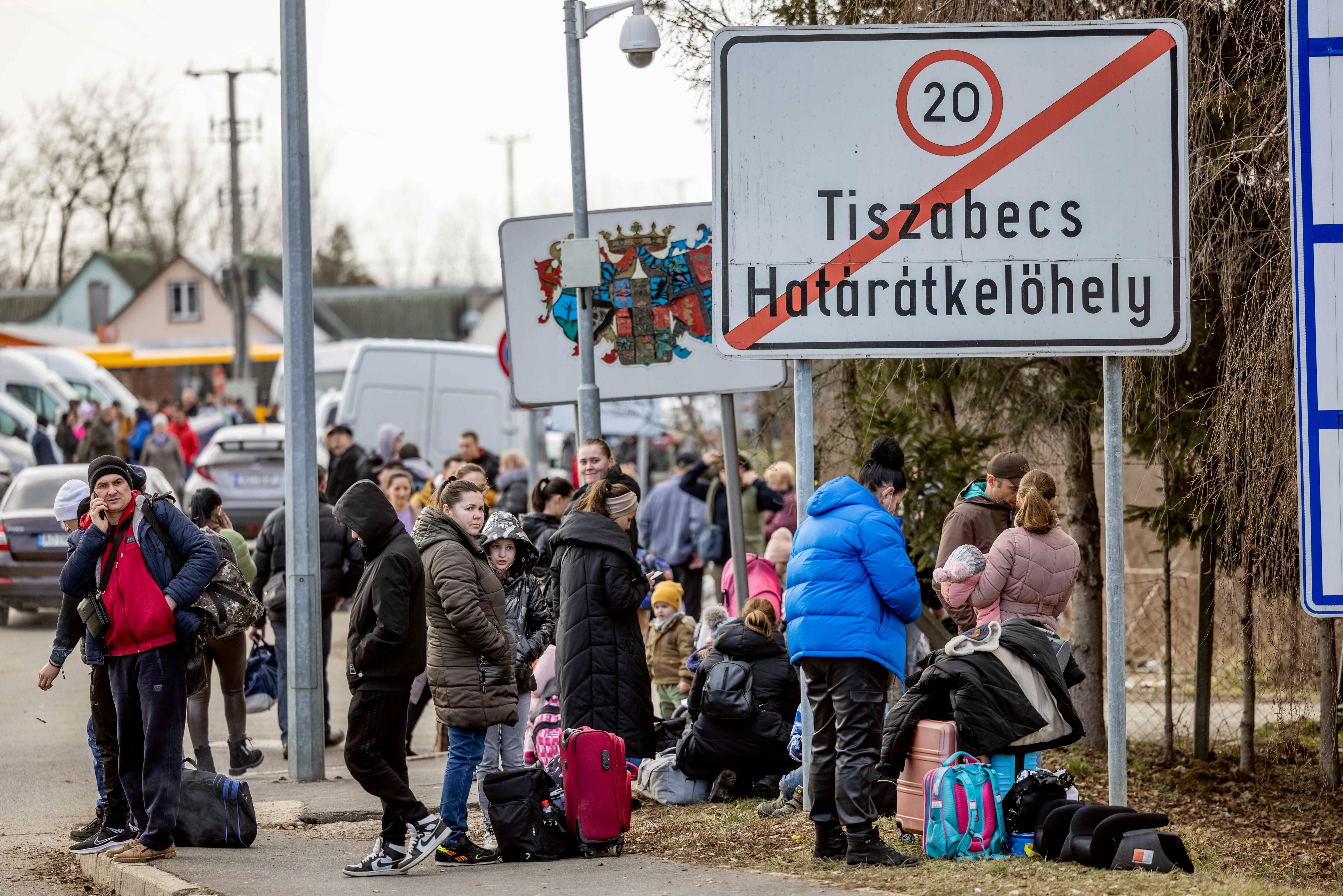 TISZABECS, HUNGARY - FEBRUARY 25: People wait with their belongings at the Tiszabecs-Tiszaujlak border crossing as they flee Ukraine on February 25, 2022 in Tiszabecs, Hungary. Long queues have already formed at the Hungarian-Ukrainian border crossings after Russia began a large-scale attack on Ukraine in the early hours of February 24, with explosions reported in multiple cities and far outside the restive eastern regions held by Russian-backed rebels. (Photo by Janos Kummer/Getty Images)