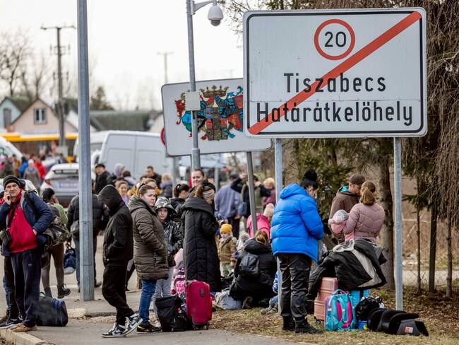 TISZABECS, HUNGARY - FEBRUARY 25: People wait with their belongings at the Tiszabecs-Tiszaujlak border crossing as they flee Ukraine on February 25, 2022 in Tiszabecs, Hungary. Long queues have already formed at the Hungarian-Ukrainian border crossings after Russia began a large-scale attack on Ukraine in the early hours of February 24, with explosions reported in multiple cities and far outside the restive eastern regions held by Russian-backed rebels. (Photo by Janos Kummer/Getty Images)