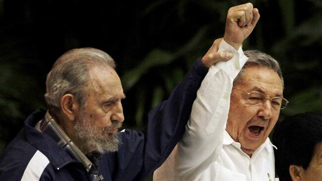 En esta foto de archivo del 19 de abril de 2011, Fidel Castro (izquierda), levanta la mano de su hermano Raúl, el presidente de Cuba, mientras ambos cantan el Himno de la Internacional Socialista.. Foto: Associated Press - AP