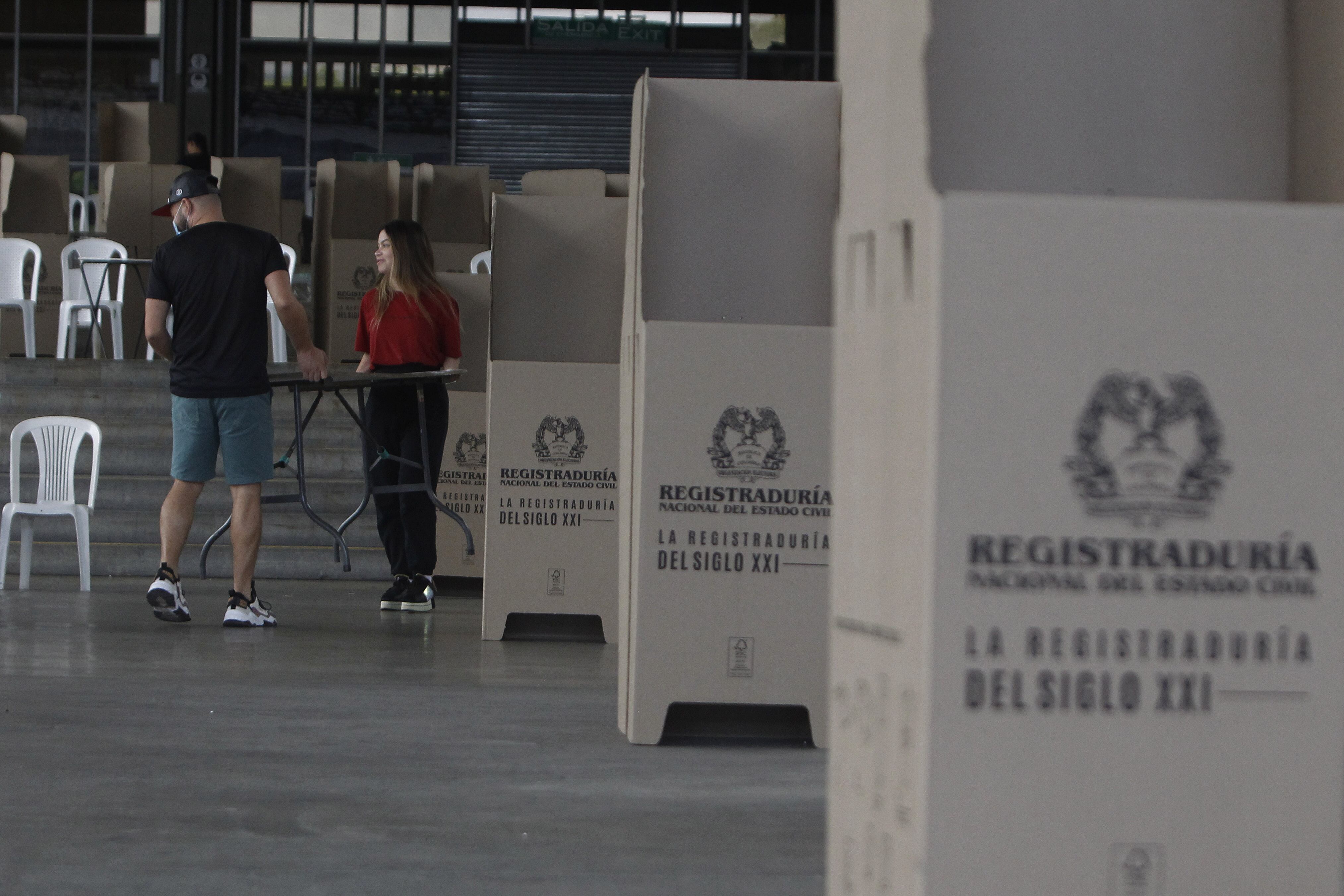 Dos funcionarios montan un puesto de votación en el recinto de Plaza Mayor en Medellín (Colombia). Este domingo los colombianos elegirán alcaldes, gobernadores concejales, diputados regionales, ediles y miembros de las juntas administrativas locales. EFE/ Luis Eduardo Noriega Arboleda