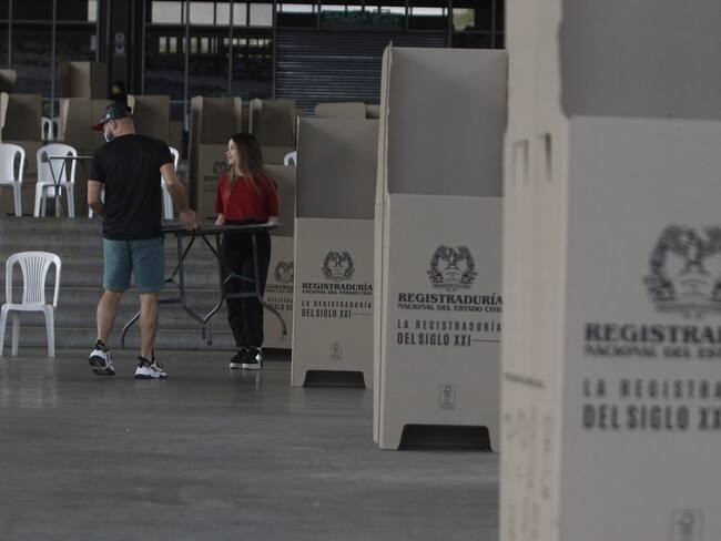 Dos funcionarios montan un puesto de votación en el recinto de Plaza Mayor en Medellín (Colombia). Este domingo los colombianos elegirán alcaldes, gobernadores concejales, diputados regionales, ediles y miembros de las juntas administrativas locales. EFE/ Luis Eduardo Noriega Arboleda