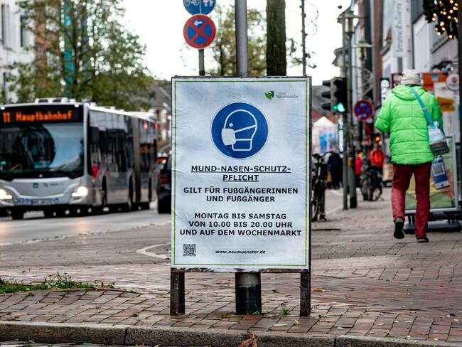 22 November 2021, Schleswig-Holstein, Neumünster: A sign indicating the obligation to wear a mask for pedestrians stands in Neumünster city centre near the railway station.A mask obligation has again been in force in Neumünster city centre since 22 November 2021. Photo: Axel Heimken/dpa (Photo by Axel Heimken/picture alliance via Getty Images)