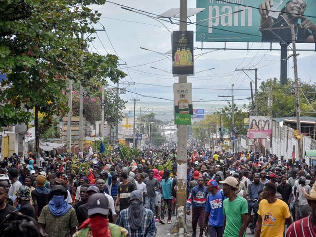Policías vigilan a manifestantes que participan de una gran protesta antigubernamental en Puerto Príncipe (Haití). EFE/ Siffroy Clarens