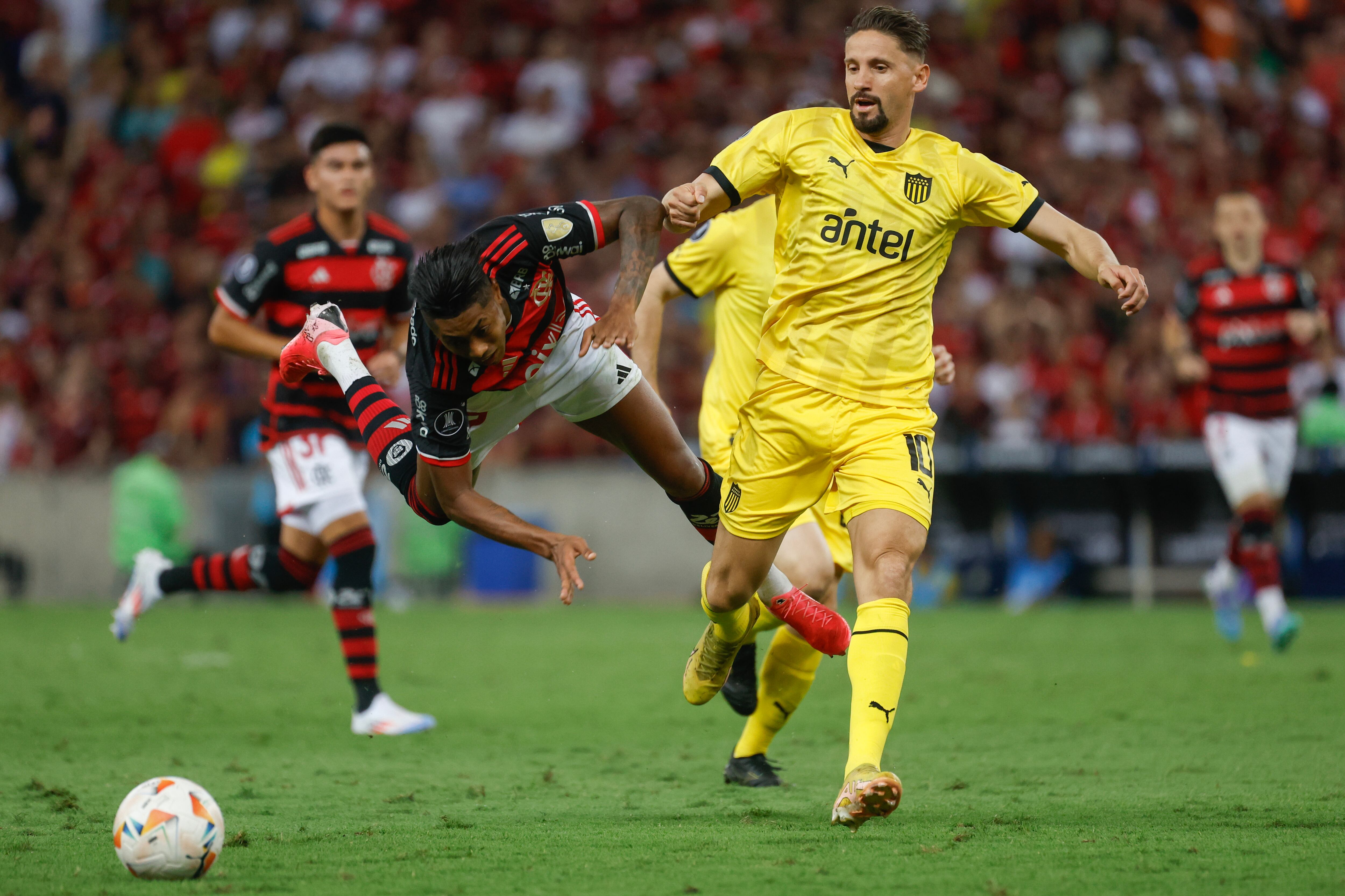 AMDEP7429. RÍO DE JANEIRO (BRASIL), 19/09/2024.- Bruno Henrique Pinto (i) de Flamengo disputa un balón con Gastón Ramírez de Peñarol este jueves, en el partido de ida de cuartos de final de la Copa Libertadores entre Flamengo y Peñarol en el estadio Maracaná en Río de Janeiro (Brasil). EFE/ Antonio Lacerda