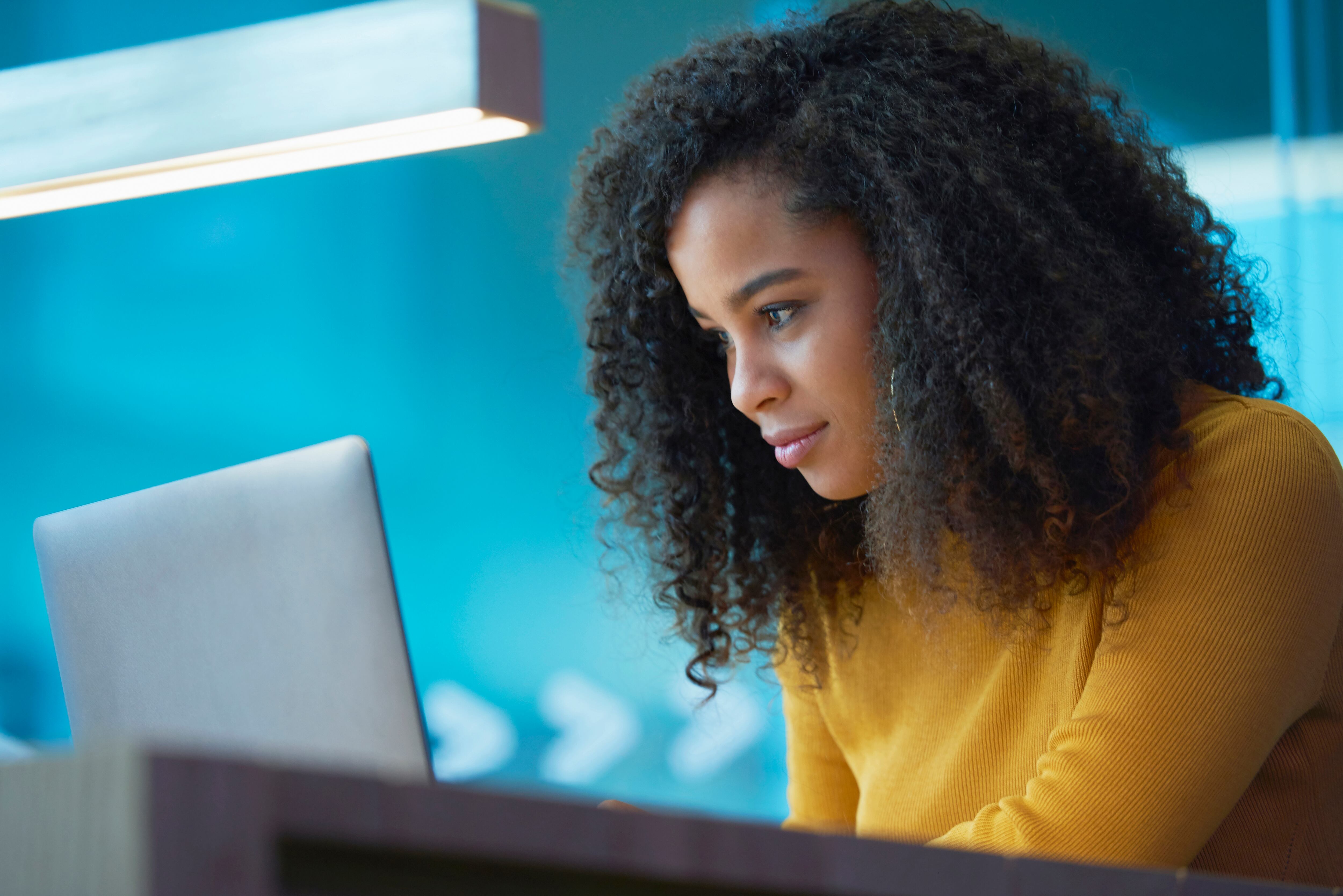 Mujer usando su computador para buscar empleo (GettyImages)