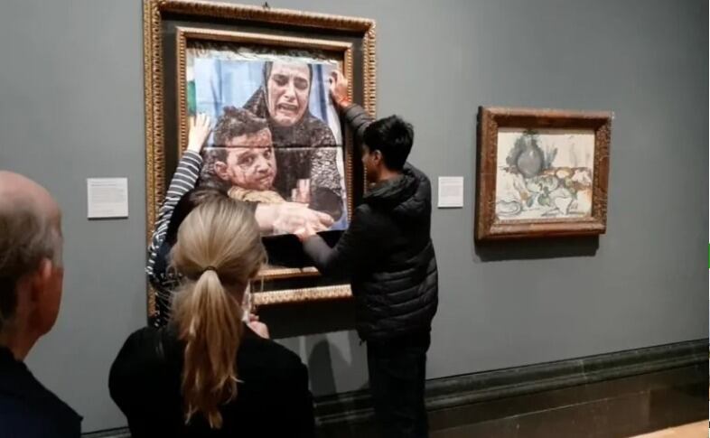 Activistas cubriendo la obra "Maternidad" de Picasso. I Foto: AFP.