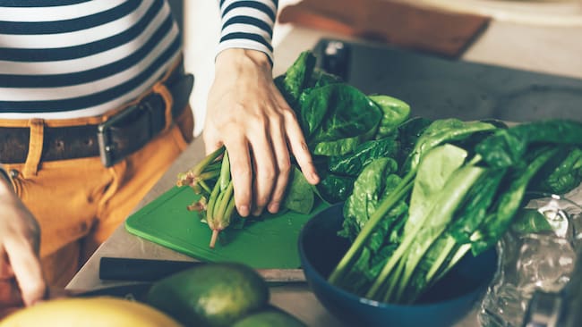 Persona preparando comida con vegetales (Foto vía Getty Images)