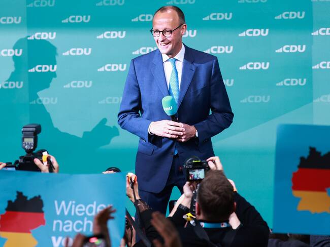 BERLÍN (Alemania), 23/02/2025.- El presidente de la Unión Cristianodemócrata, Friedrich Merz, reacciona mientras se ve al fondo la sombra del primer ministro de Baviera y presidente de la Unión Socialcristiana, Markus Soeder.