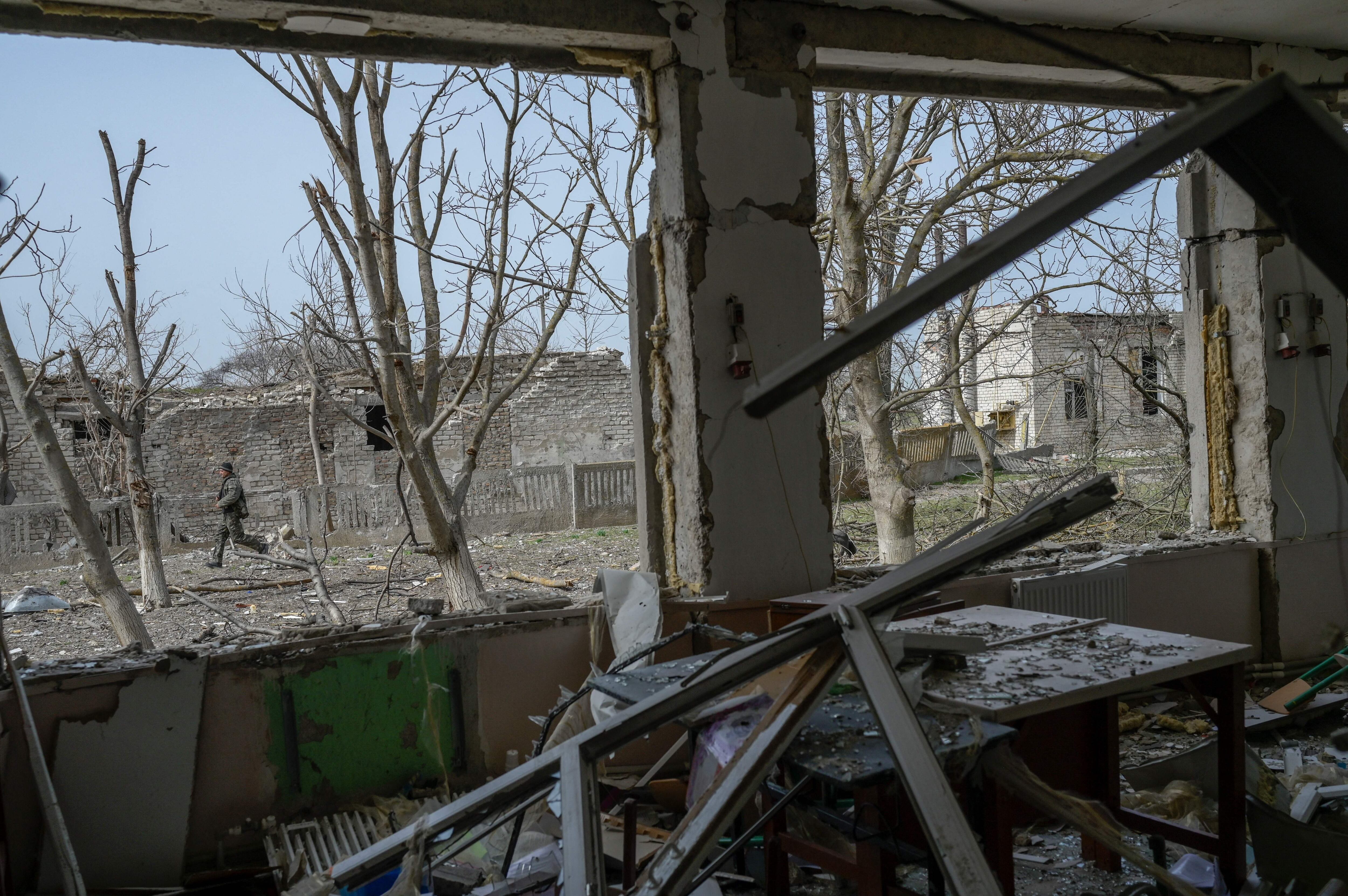 A Ukrainian soldier walks outside a school hit by Russian rockets in the southern Ukraine village of Zelenyi Hai between Kherson and Mykolaiv. (Photo by BULENT KILIC / AFP) (Photo by BULENT KILIC/AFP via Getty Images)
