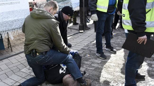 Una foto de la agencia finlandesa Lehtikuva difundida por los medios nacionales muestran un hombre en el suelo, reducido por dos escoltas. Foto: Agencia AFP