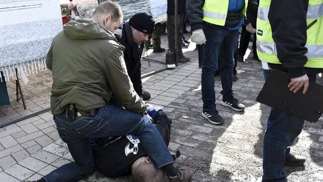 Una foto de la agencia finlandesa Lehtikuva difundida por los medios nacionales muestran un hombre en el suelo, reducido por dos escoltas. Foto: Agencia AFP