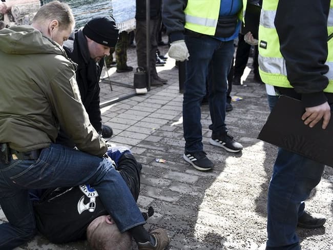 Una foto de la agencia finlandesa Lehtikuva difundida por los medios nacionales muestran un hombre en el suelo, reducido por dos escoltas. Foto: Agencia AFP