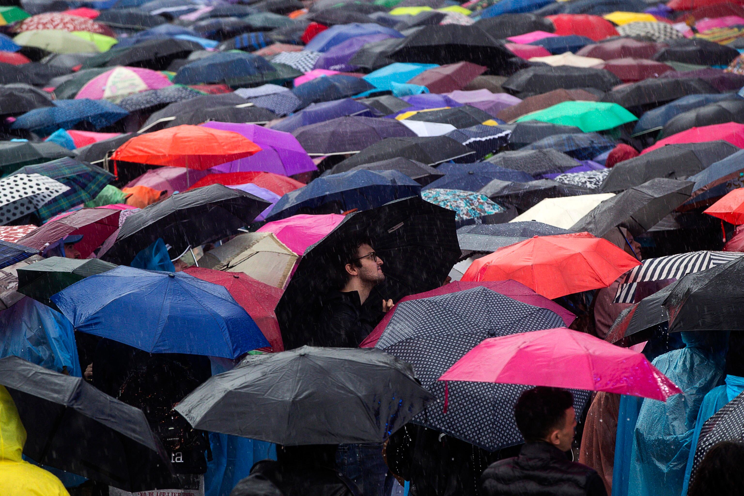 -FOTODELDÍA- ROMA, 01/05/2024.- Manifestantes se protegen de la lluvia durante una concentración convocada por los sindicatos CGIL, CISL y UIL con motivo del Día Internacional del Trabajo, este miércoles en el Circo Massimo de Roma. EFE/ANGELO CARCONI
