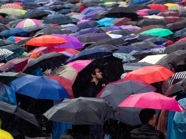 -FOTODELDÍA- ROMA, 01/05/2024.- Manifestantes se protegen de la lluvia durante una concentración convocada por los sindicatos CGIL, CISL y UIL con motivo del Día Internacional del Trabajo, este miércoles en el Circo Massimo de Roma. EFE/ANGELO CARCONI

