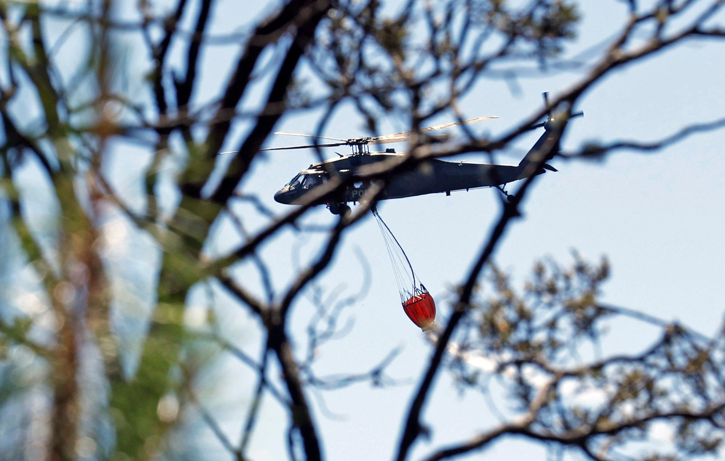 Fotografía de un helicóptero mientras hace una descarga de agua en la zona de un incendio forestal en el cerro El Cable, en Bogotá (Colombia). EFE/ Mauricio Dueñas Castañeda