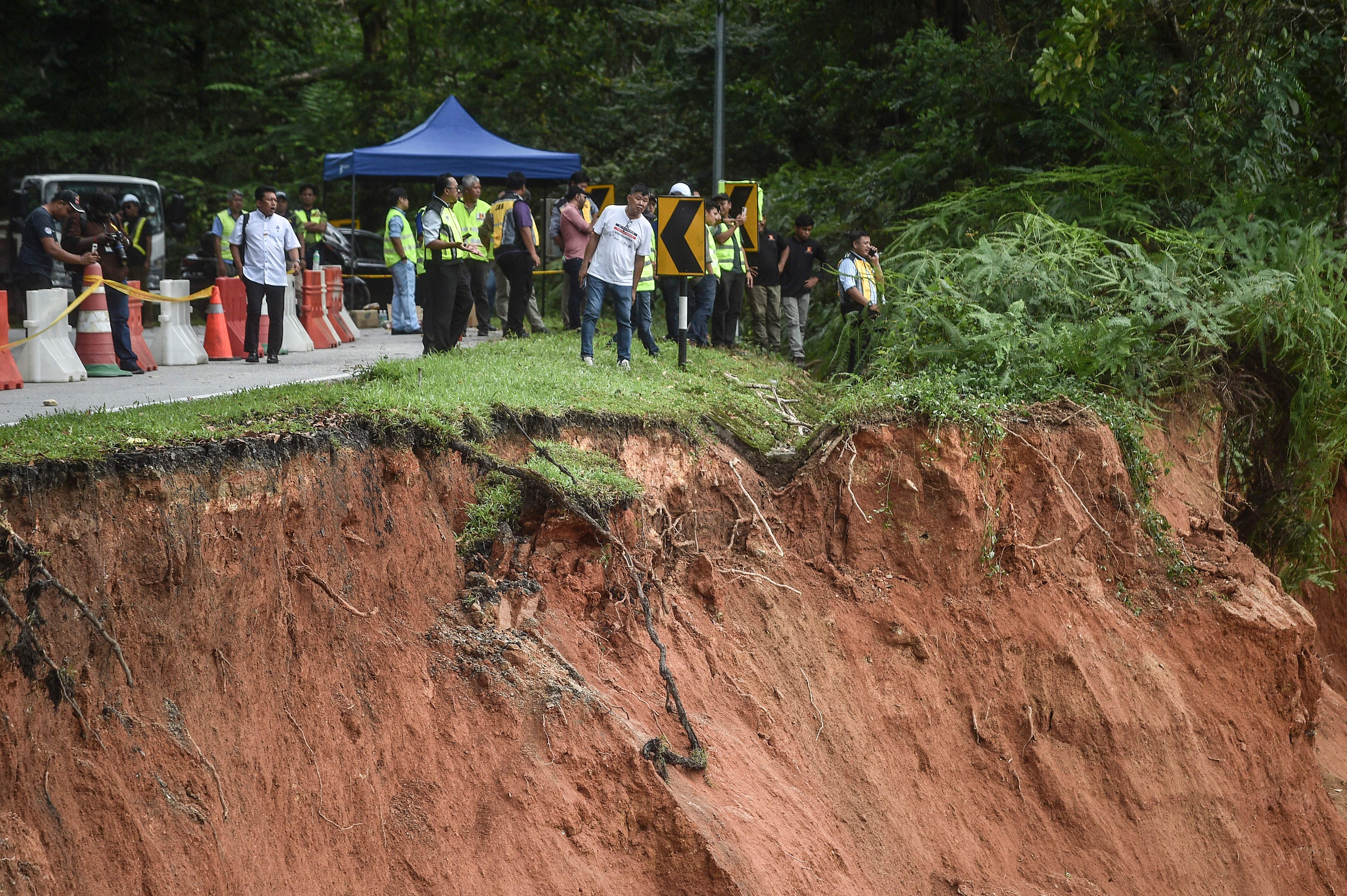 Personas inspeccionan los daños después de un deslizamiento de tierra en Batang Kali, Selangor, el 16 de diciembre de 2022.