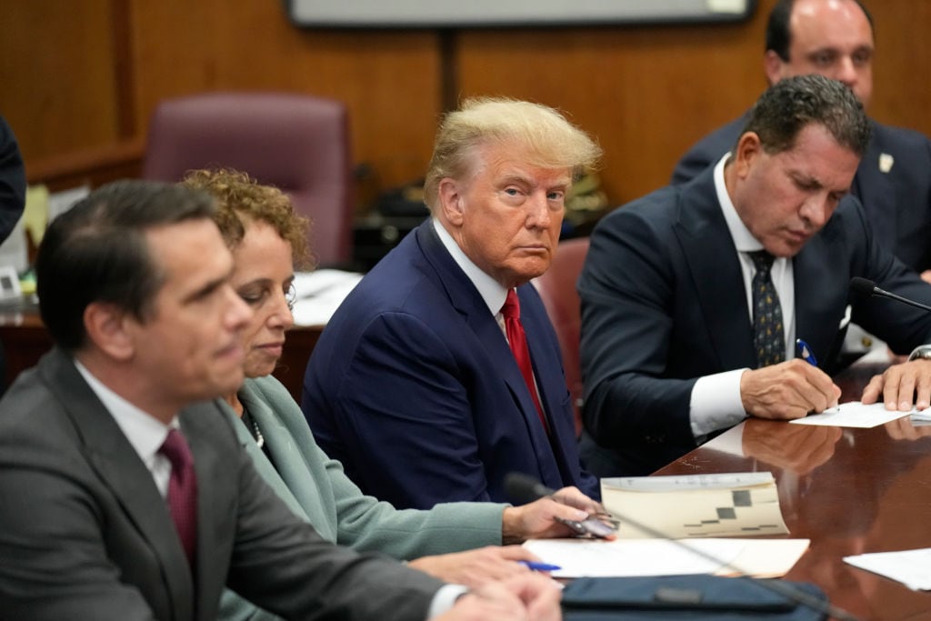 NEW YORK, NEW YORK - APRIL 04: Former U.S. President Donald Trump sits at the defense table with his defense team in a Manhattan court during his arraignment on April 4, 2023, in New York City. Trump was arraigned during his first court appearance today following an indictment by a grand jury that heard evidence about money paid to adult film star Stormy Daniels before the 2016 presidential election. With the indictment, Trump becomes the first former U.S. president in history to be charged with a criminal offense. (Photo by Seth Wenig-Pool/Getty Images)