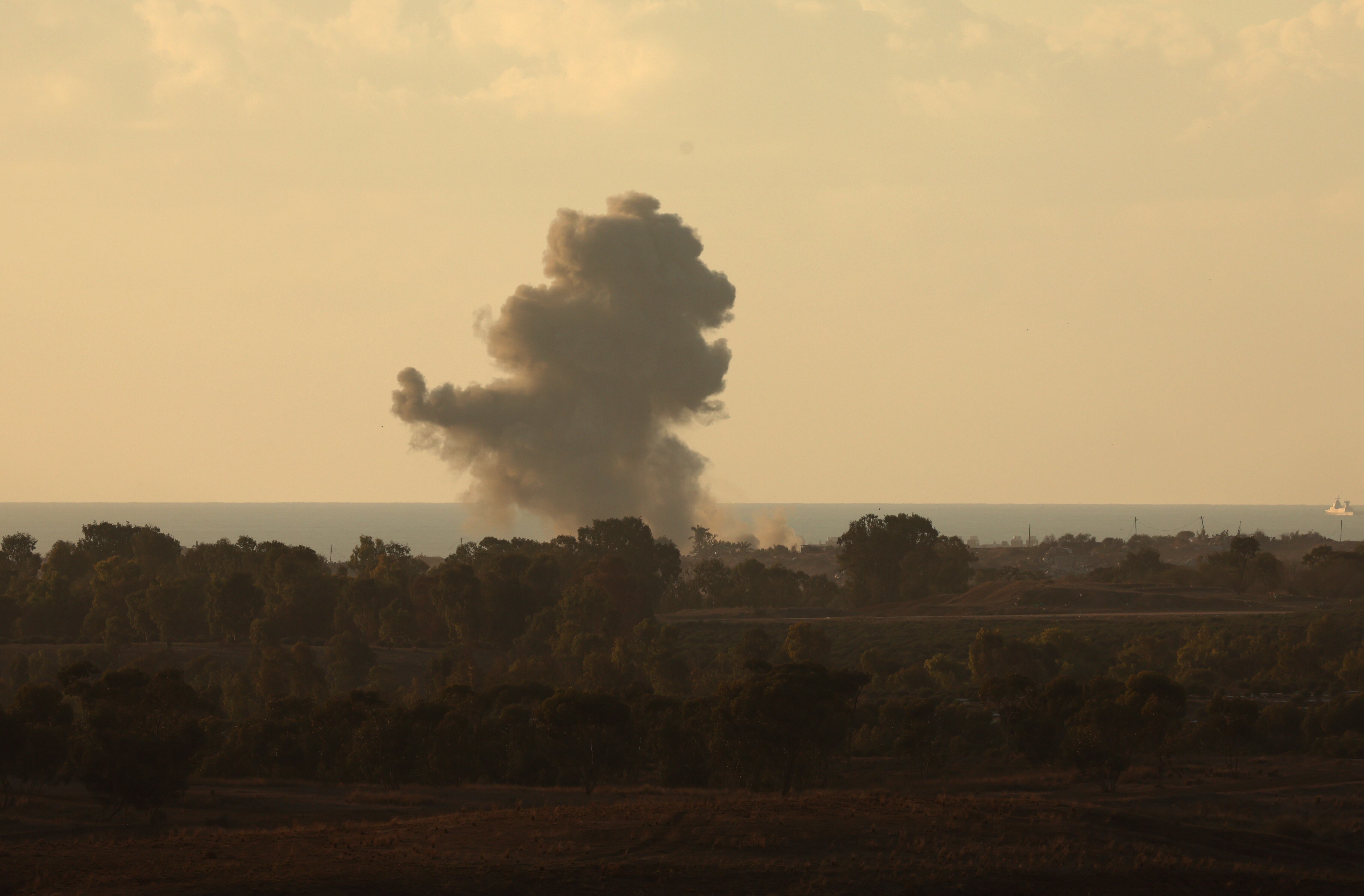 Be'eri (Israel), 21/11/2023.- An Israeli Navy ship (R) sails on the horizon as smoke rises after an explosion on the outskirts of Gaza city, as seen from Be'eri, southern Israel, 21 November 2023. As part of Israel's 'ground operations' in the Gaza Strip, Israeli military aircraft struck approximately 250 Hamas targets over the last day, the IDF announced on 21 November. More than 12,500 Palestinians and at least 1,200 Israelis have been killed, according to the Israel Defense Forces (IDF) and the Palestinian health authority, since Hamas militants launched an attack against Israel from the Gaza Strip on 07 October, and the Israeli operations in Gaza and the West Bank which followed it. EFE/EPA/ATEF SAFADI
