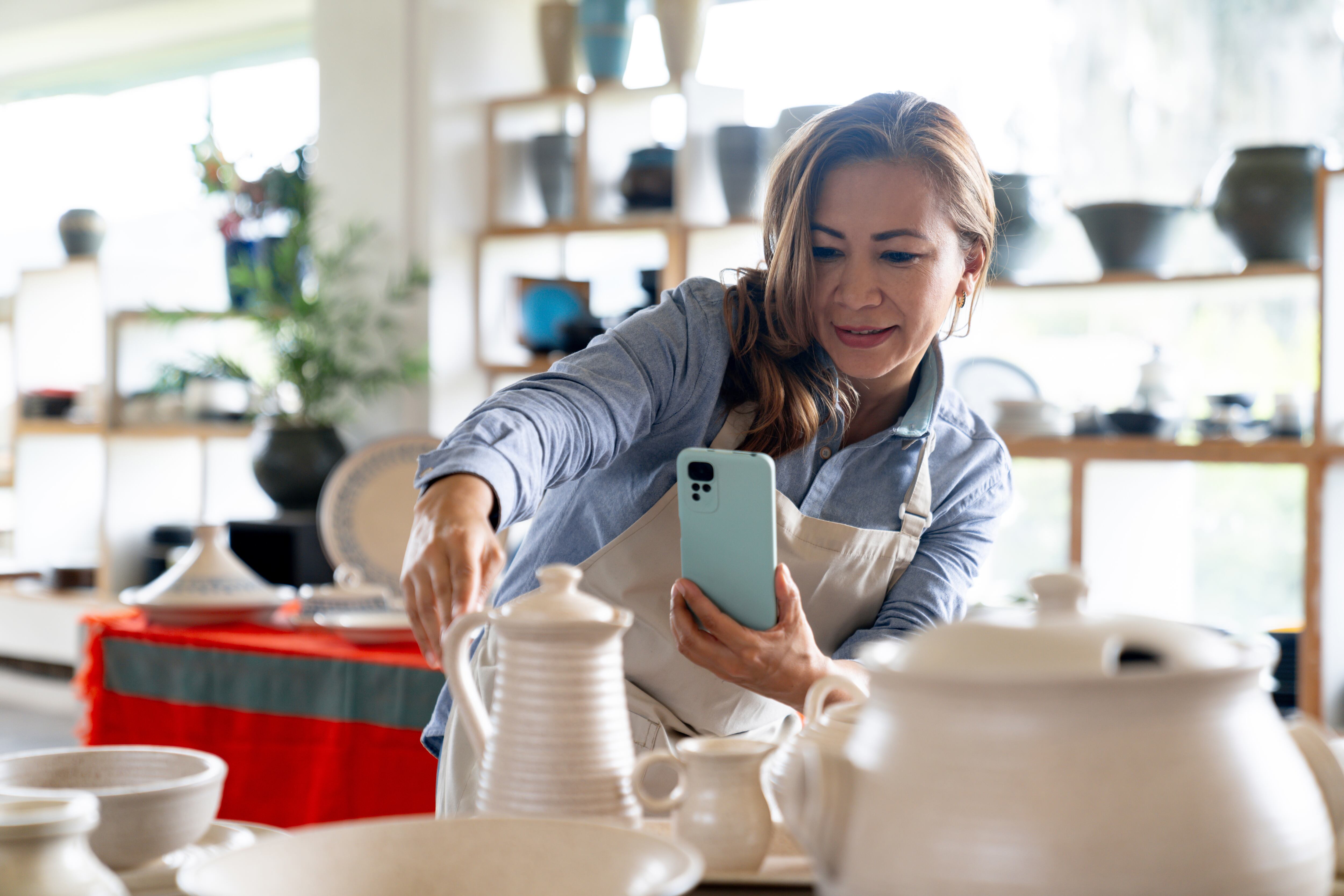 Imagen de referencia de una mujer trabajadora independiente tomando una foto de sus productos. Getty Images