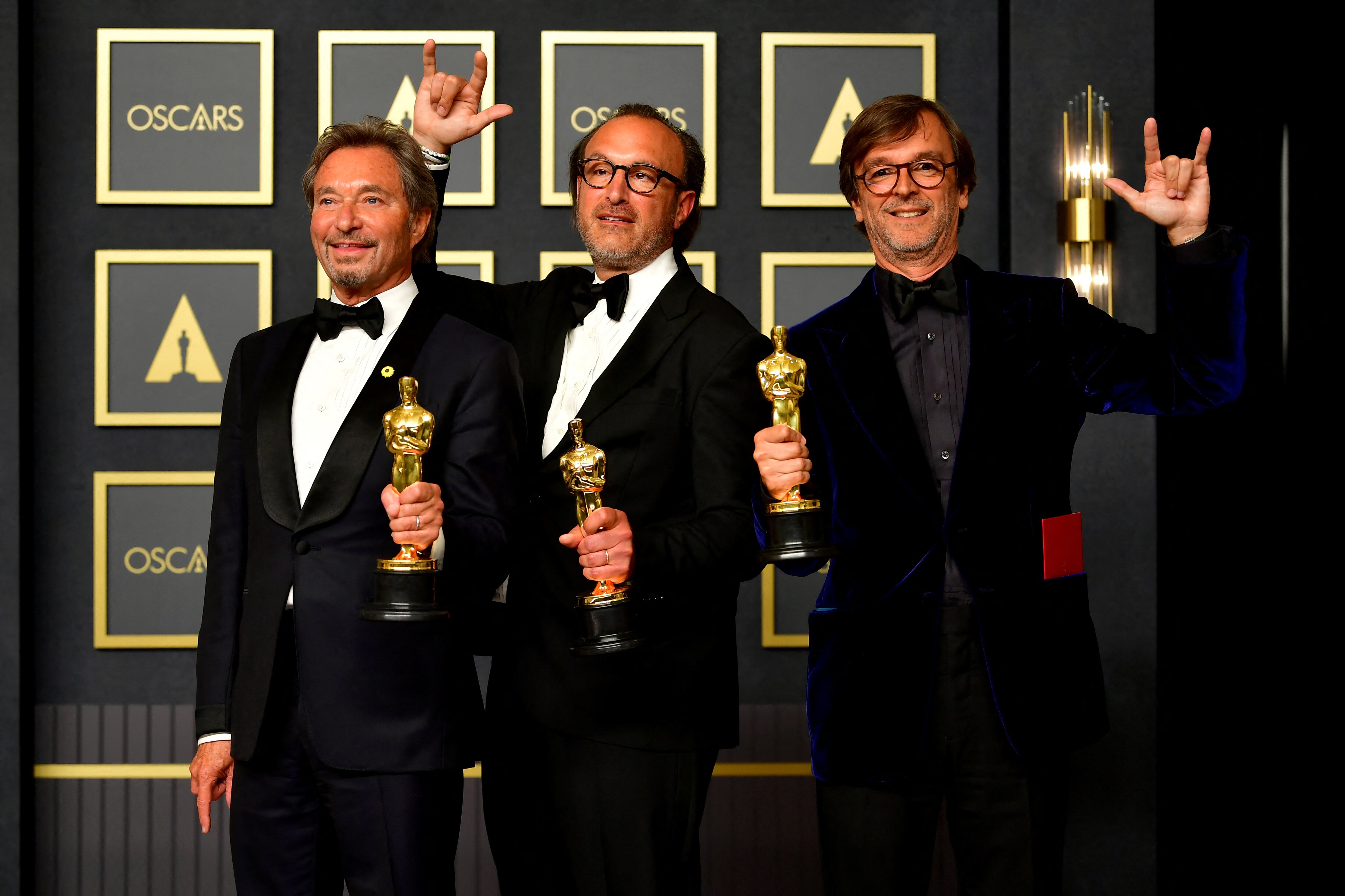 Los productores Philippe Rousselet, Fabrice Gianfermi, y Patrick Wachsberger posan con el premio a la Mejor Película por 'CODA'. Foto: Frédéric J. Brown / AFP