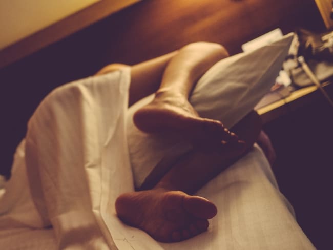 Persona durmiendo con almohada entre las piernas // Foto: Getty Images