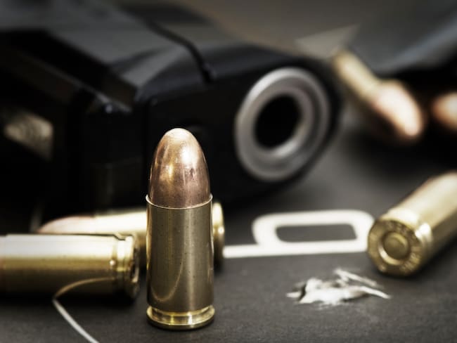 Imagen de referencia de pistola con balas. Foto: Getty Images.