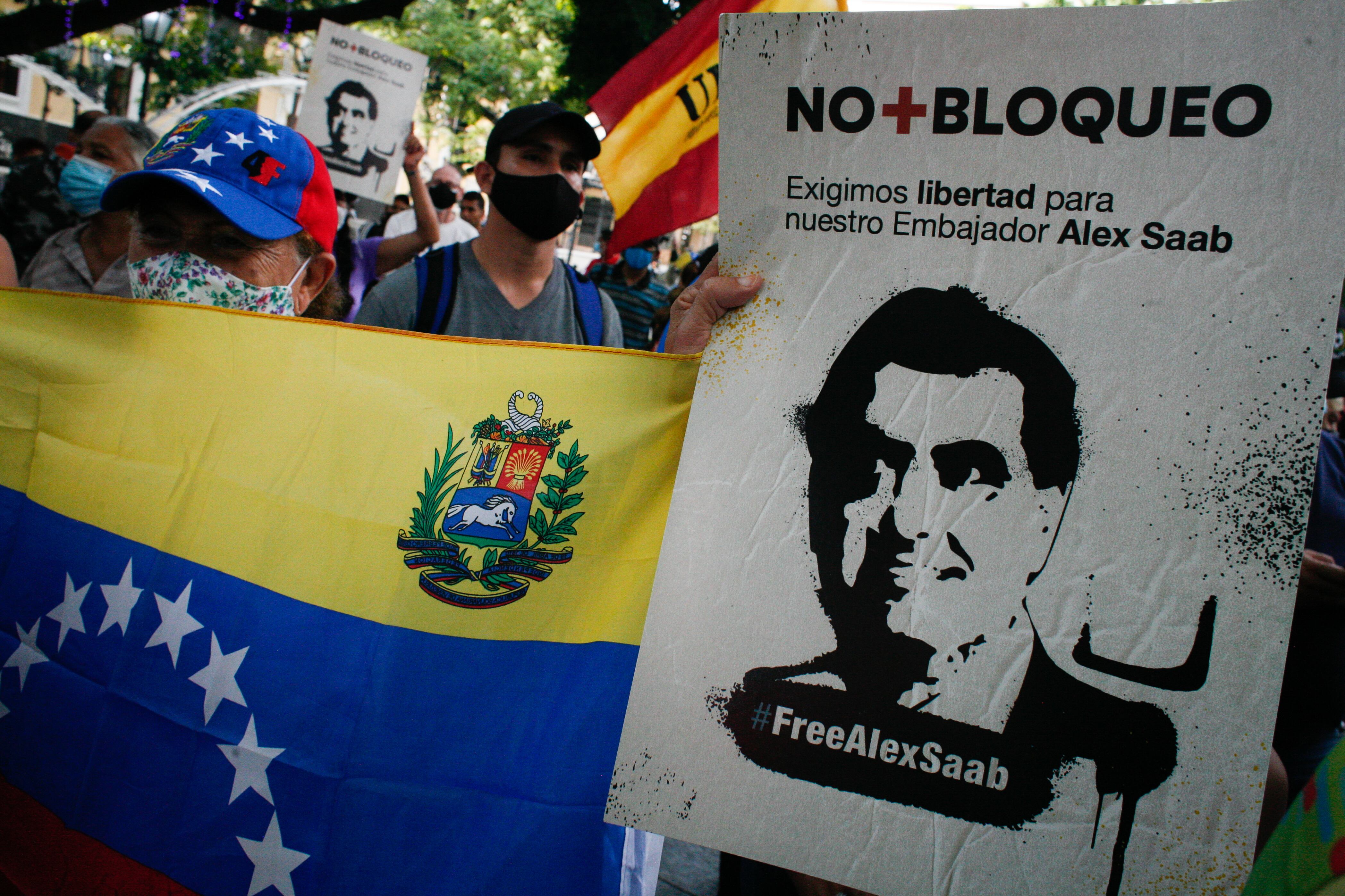 People hold signs calling for the release of Alex Saab at a rally in solidarity with the Colombian businessman after his extradition to the United States from Cape Verde, amid the Coronavirus pandemic in Caracas, Venezuela on October 17, 2021. (Photo by Javier Campos/NurPhoto via Getty Images)