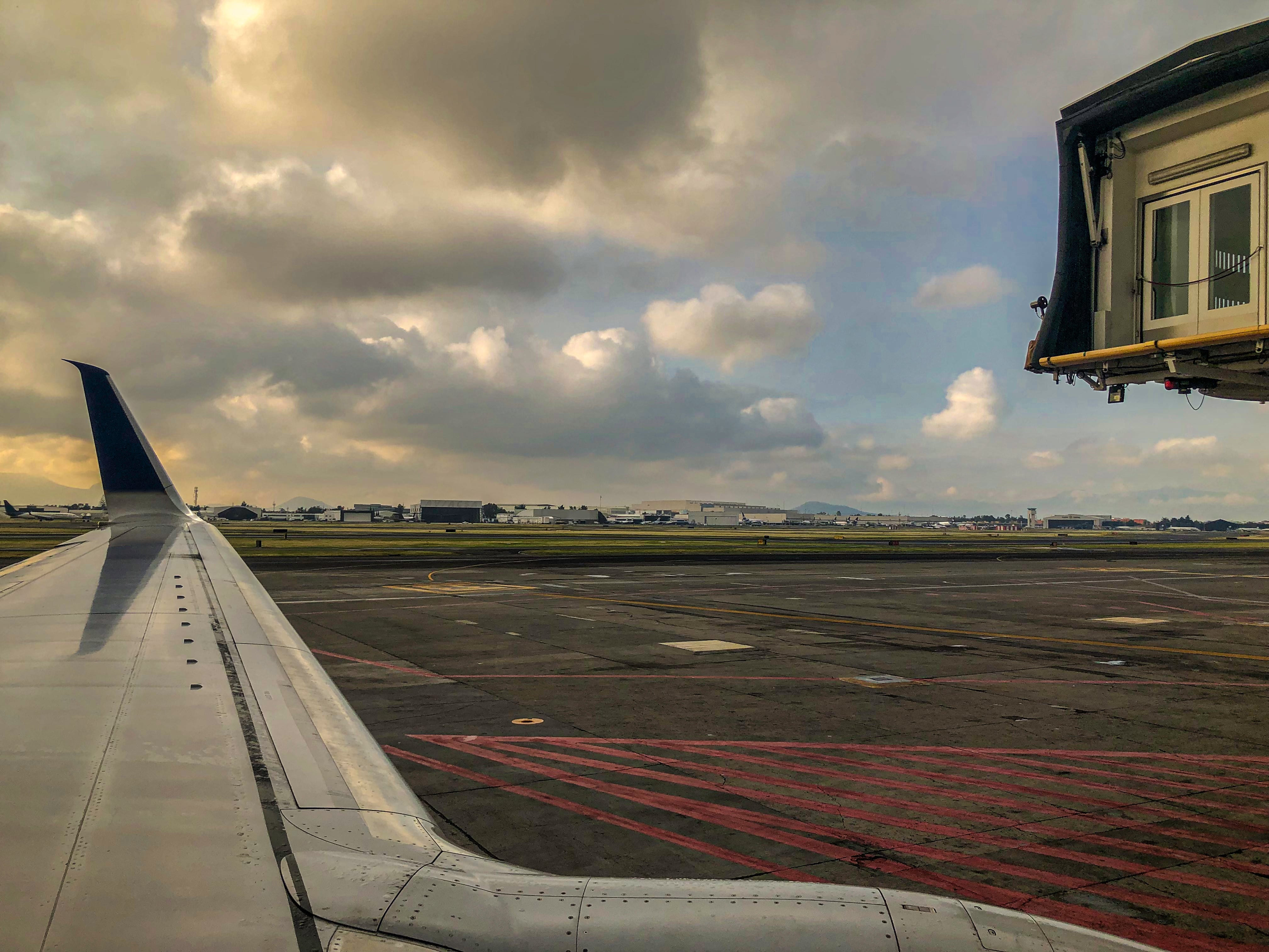 Shot in early morning the plane is exciting the gate, the plane is moving toward lift off to start traveling the sky is beautiful has really interesting and colorful colors