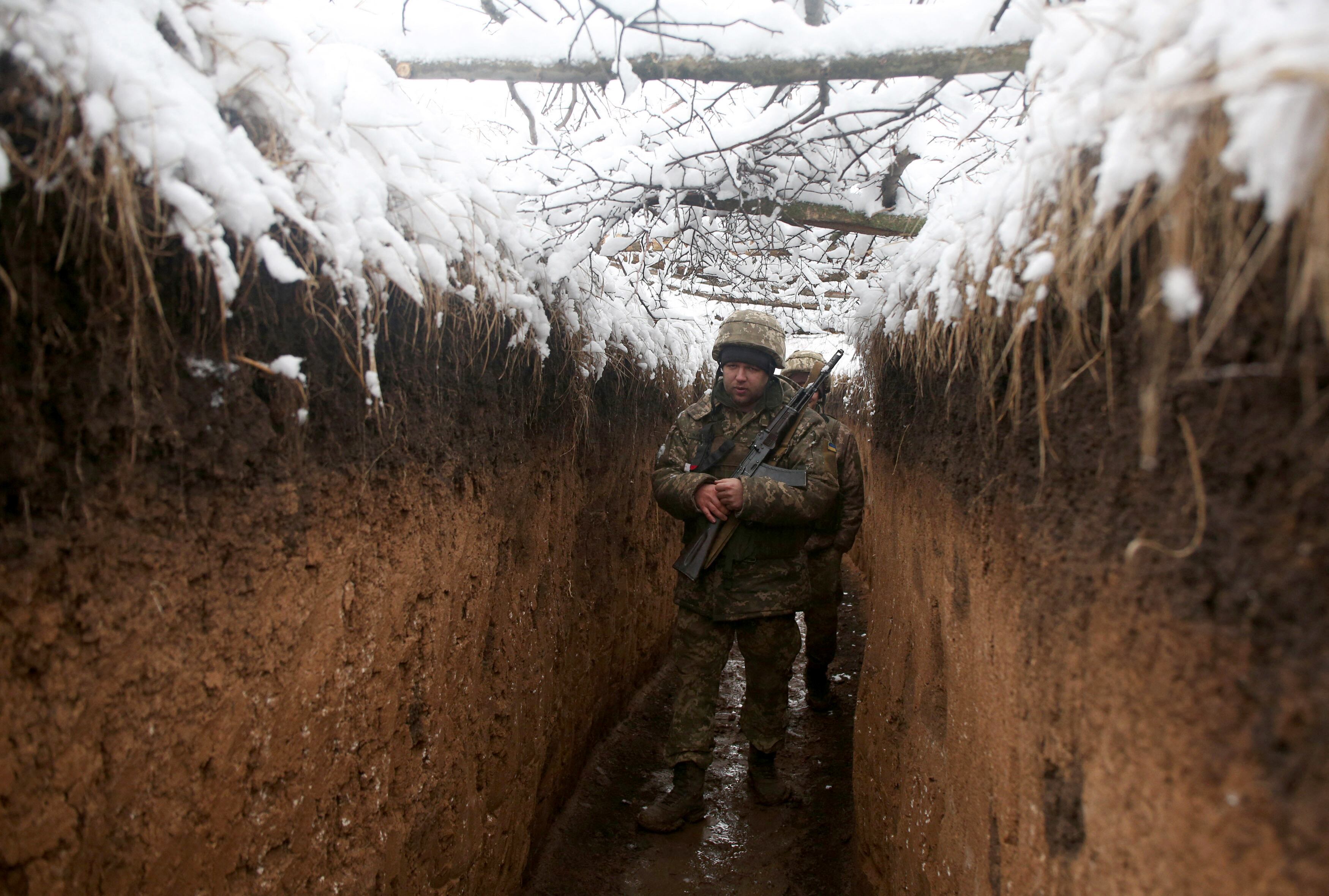 Ukrainian servicemen walk in a trench on their position on the front line with Russia-backed separatists near small town of Svitlodarsk, Donetsk region on December 18, 2021. (Photo by Anatolii STEPANOV / AFP) (Photo by ANATOLII STEPANOV/AFP via Getty Images)