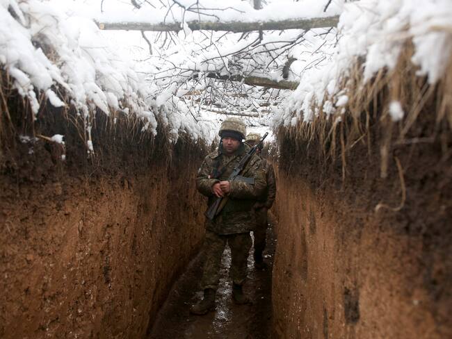 Ukrainian servicemen walk in a trench on their position on the front line with Russia-backed separatists near small town of Svitlodarsk, Donetsk region on December 18, 2021. (Photo by Anatolii STEPANOV / AFP) (Photo by ANATOLII STEPANOV/AFP via Getty Images)